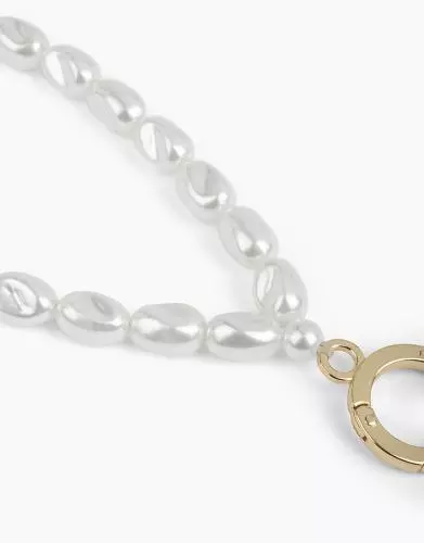 Nahaufnahme einer eleganten Halskette mit weißen Perlen und einem goldfarbenen Verschluss