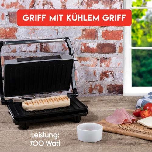 Elektrischer Grill mit Sandwichzubereitung auf Holztisch, umgeben von Zutaten wie Schinken und Tomaten