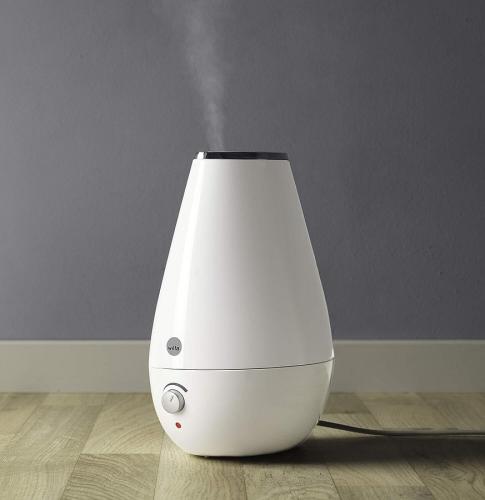 Weißer Luftbefeuchter in modernem Design steht auf Holzboden