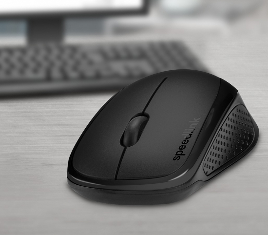 Schwarze kabellose Maus mit ergonomischem Design auf einem Holztisch vor unscharfer Tastatur und Bildschirm