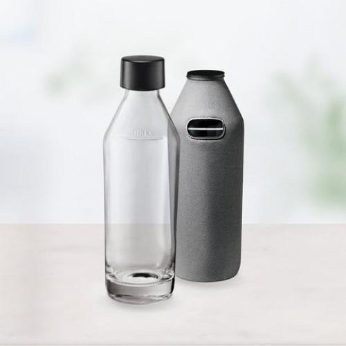 Glasflasche mit schwarzem Verschluss und grauer Abdeckung auf einem Tisch